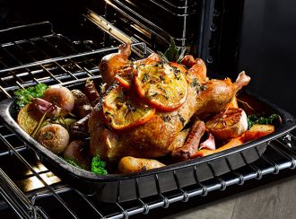 A roast chicken dinner cooking in a Belling cooker