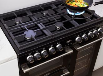 A Belling Cooktop with a stirfry cooking in a wok on a gas ring