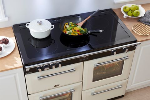 Black Richmond Induction Cooktop with a white ceramic pot and a wok containing a stir fry on top