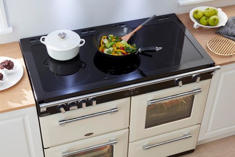 Black Richmond Induction Cooktop with a white ceramic pot and a wok containing a stir fry on top